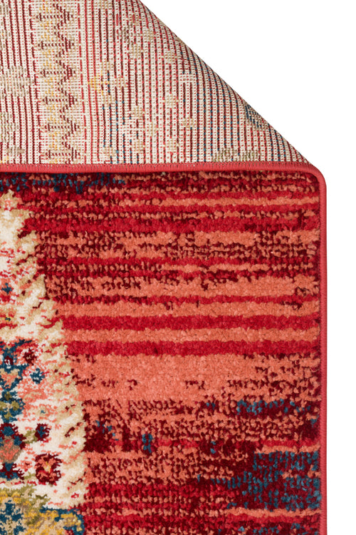 Load image 1 in gallery view. Red and coral distressed area rug with a folded corner revealing a striped backing and a textured, multi-colored pattern.