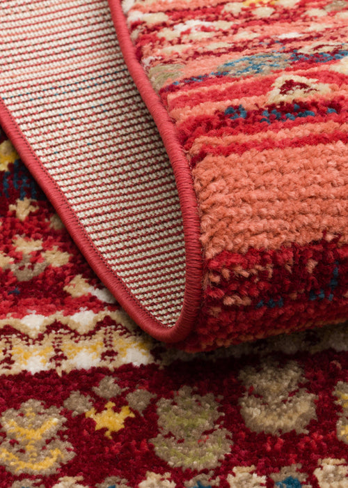 Load image 1 in gallery view. Red, coral, and beige rug with a textured, repeating floral pattern and a red bound edge showing the woven backing.
