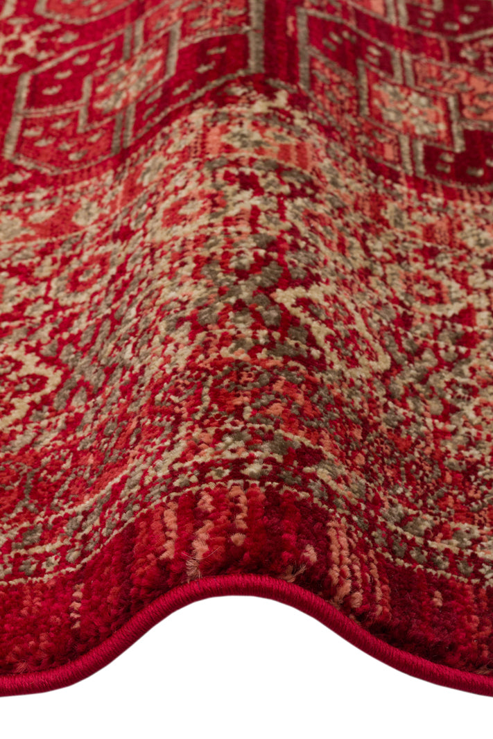 Red and beige traditional rug with a distressed medallion pattern, shown in a folded close-up view.