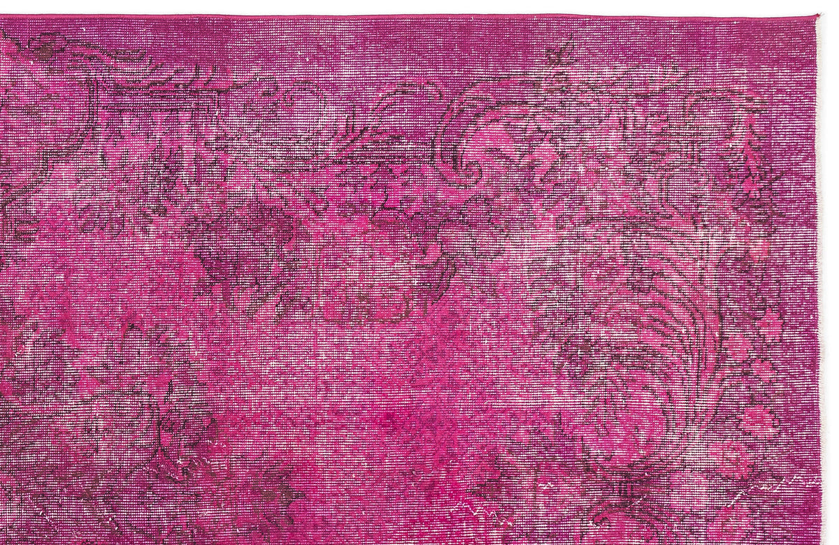 Magenta distressed rug with a faded dark floral medallion pattern on a white background.