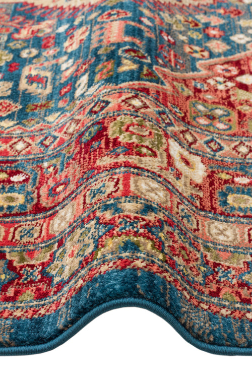 Load image 1 in gallery view. Blue and red traditional Persian-style rug with intricate floral and geometric patterns, shown folded.