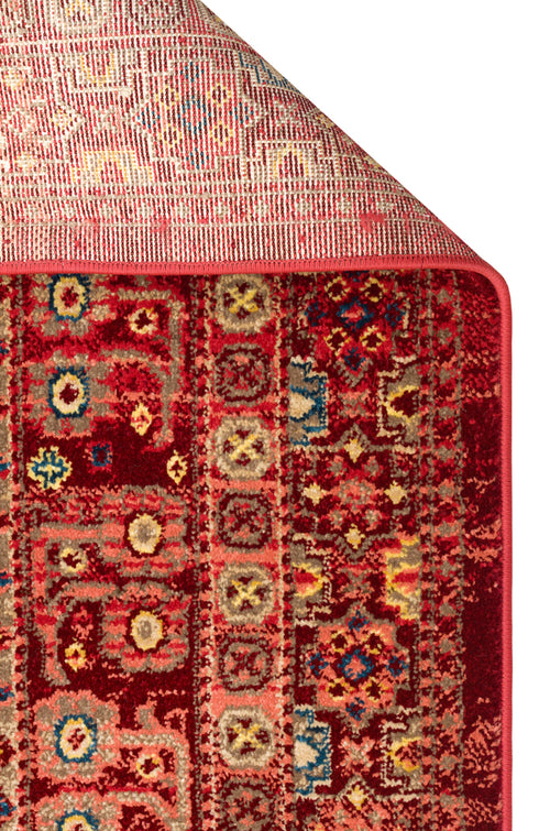 Load image 1 in gallery view. Deep red traditional rug with a geometric medallion pattern in blue, yellow, and beige, shown with a folded corner.