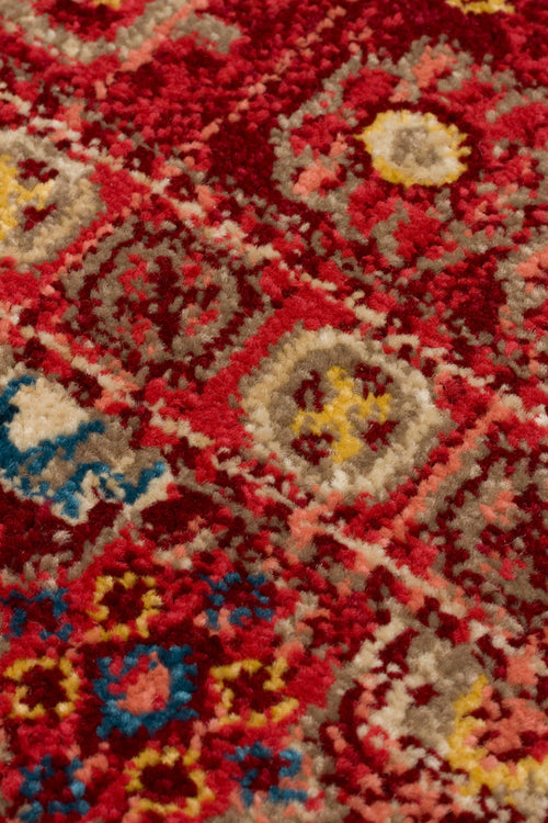 Load image 1 in gallery view. Close-up of a deep red rug with a repeating geometric medallion pattern in beige, yellow, and blue.