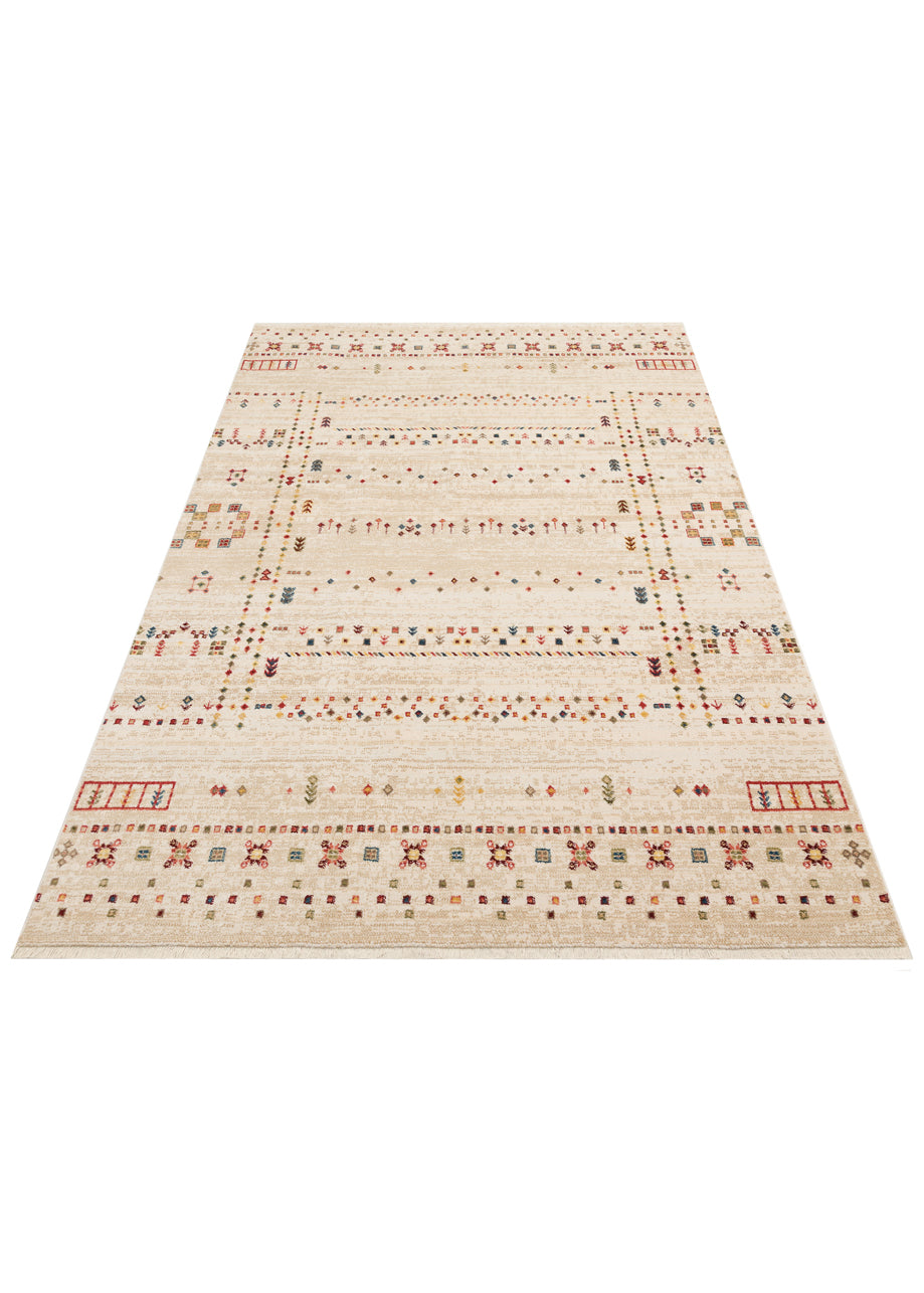 Cream area rug with a distressed finish, featuring multicolored geometric tribal motifs and a fringed edge.