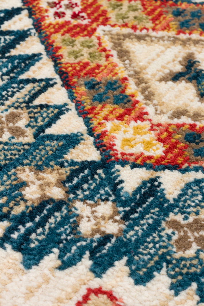Close-up of a high-pile rug featuring a traditional medallion pattern in teal, red, yellow, and beige.