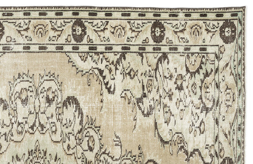 Load image 1 in gallery view. The Vaerail Vintage Medallion Rug (6'3" x 8'9") features a beige and cream palette with ornate floral and vine patterns, plus a decorative border adorned with circular motifs and geometric accents.