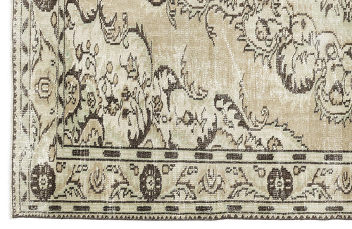 Load image 1 in gallery view. Corner of the Vaerail - Vintage Medallion Rug (6'3" x 8'9") with a beige background, dark brown floral and vine motifs, and a decorative border with stylized flowers and leaves.