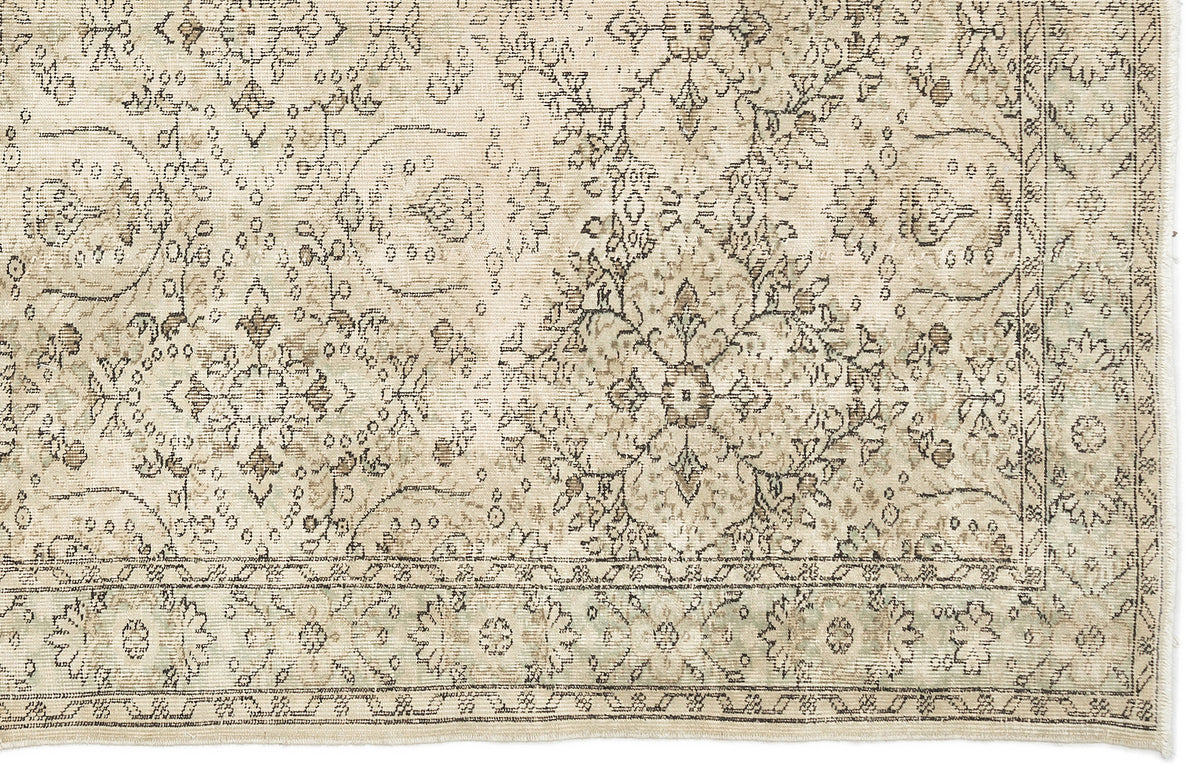 Beige and taupe vintage-style rug with a distressed floral medallion pattern and a decorative border.
