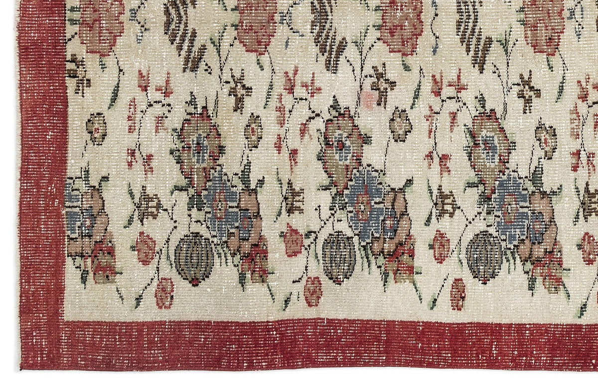 Cream rug with a distressed floral pattern in red, blue, and brown, featuring a wide red border.