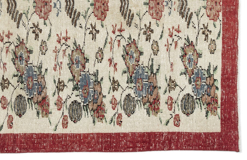 Load image 1 in gallery view. Cream rug with a distressed floral pattern in red, blue, and brown, featuring a solid red border.
