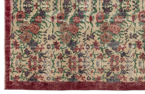 Load image 1 in gallery view. Beige rug with a distressed floral pattern in red, green, and blue, featuring a solid dark red border.