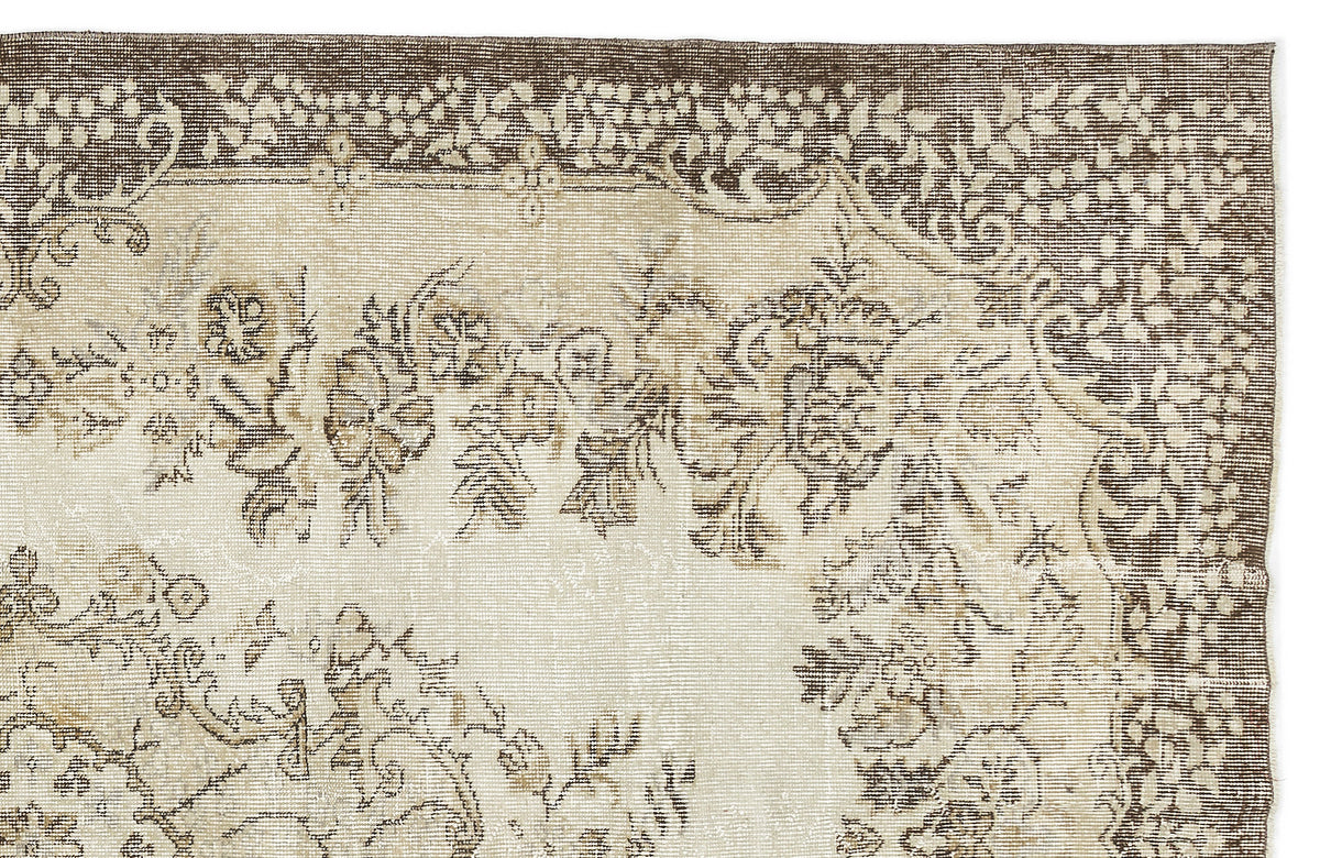 Beige and brown rug with a distressed traditional floral medallion pattern and ornate border.