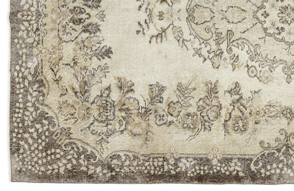 Beige and brown rug with a distressed floral medallion pattern and a decorative border.