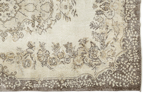 Load image 1 in gallery view. Cream and brown rug with a distressed floral medallion pattern and a detailed border.