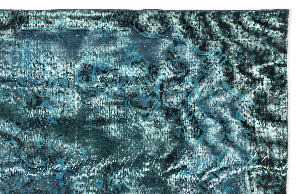 Teal and dark blue distressed rug with a faded traditional floral medallion pattern.