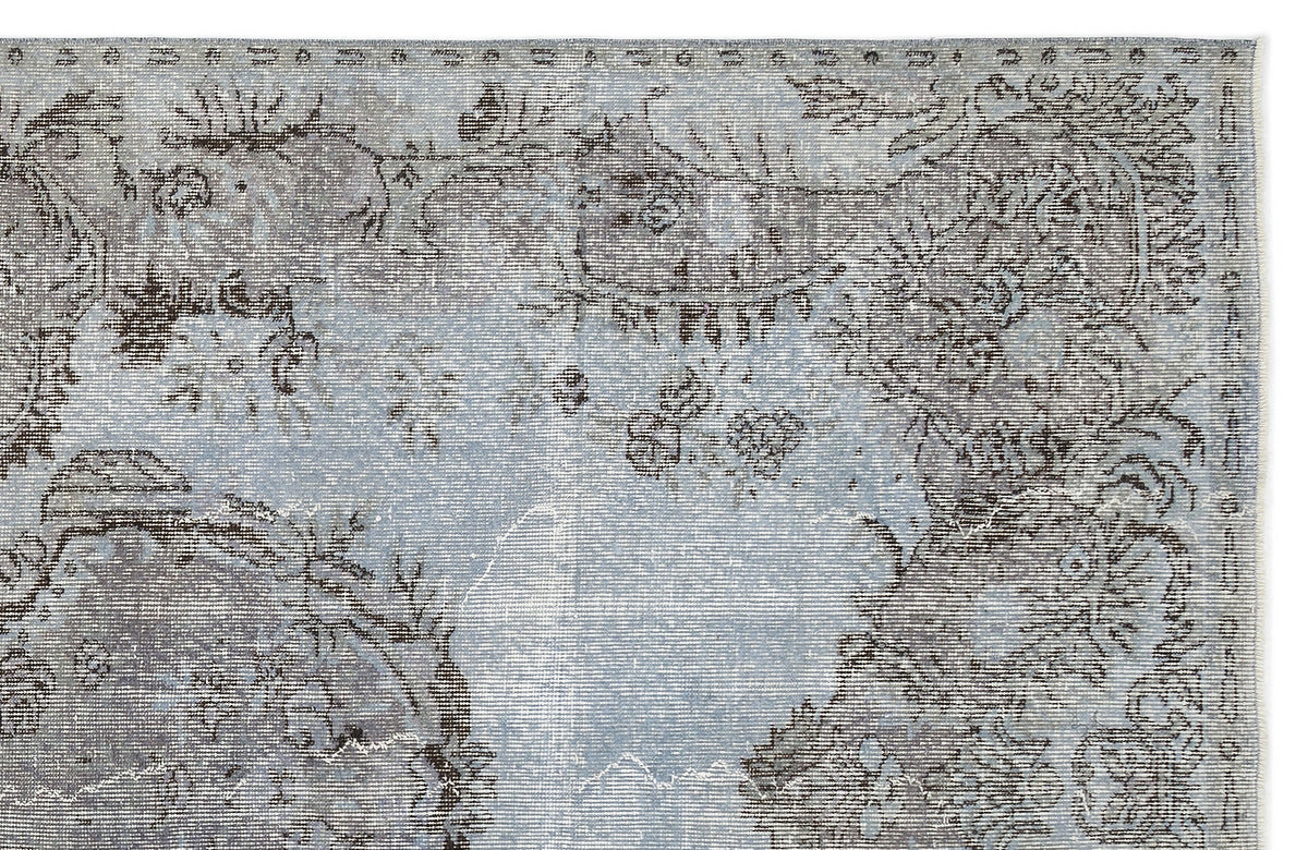 Light blue and charcoal grey rug with a distressed, traditional floral medallion pattern.
