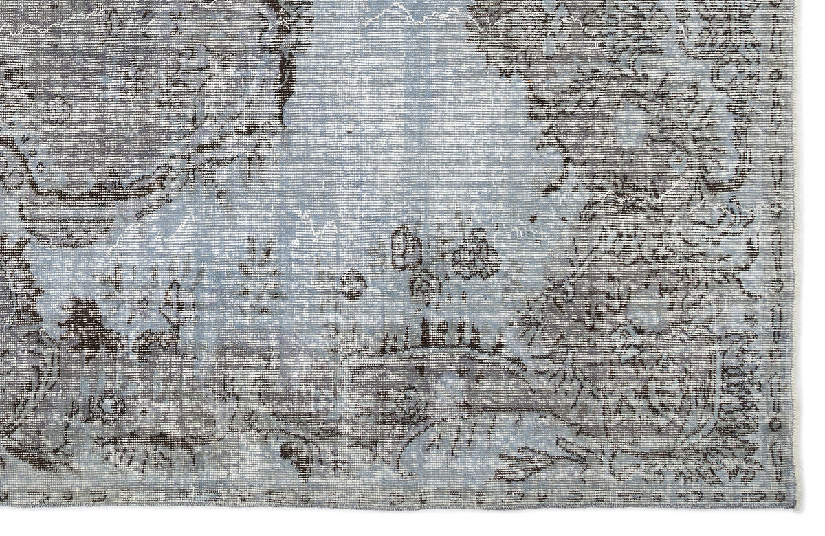 Light blue and charcoal grey distressed rug with a faded traditional floral medallion pattern.