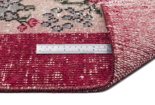 Load image 1 in gallery view. Distressed red and beige floral rug with a folded corner and a metal ruler for scale.