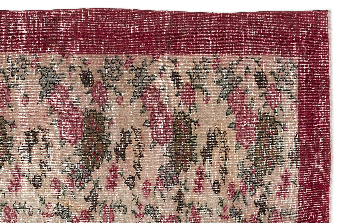 Distressed floral rug in shades of deep red, muted pink, and olive green with a solid red border.