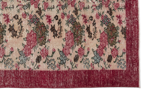 Load image 1 in gallery view. Distressed beige rug with a floral pattern in pink, olive, and grey, featuring a solid deep red border.