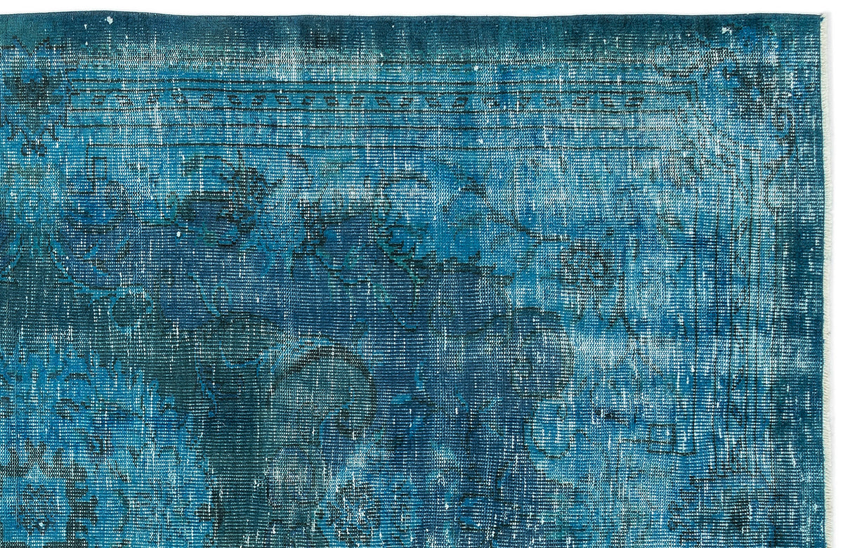 Deep blue distressed rug with a faded traditional medallion pattern and linear border detail.