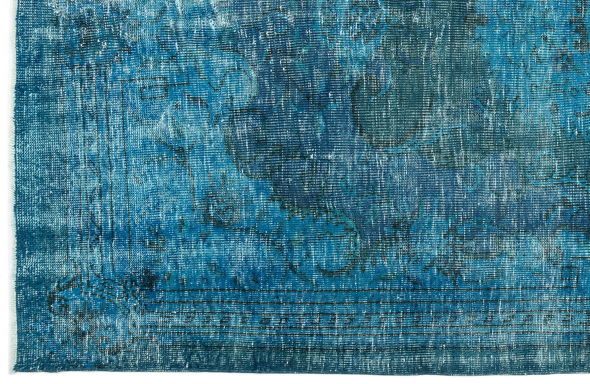 Distressed blue and navy rug with a faded traditional medallion pattern and a linear border.