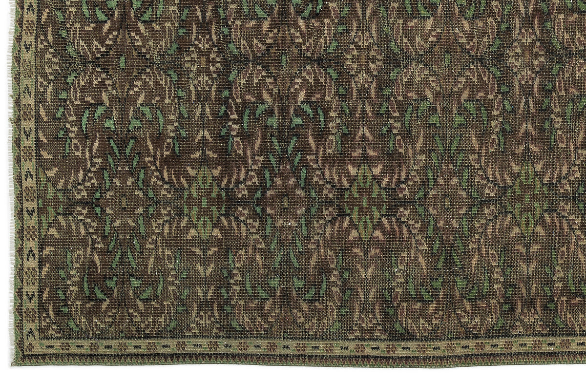 Dark brown and green traditional rug with a repeating floral medallion pattern and a narrow decorative border.