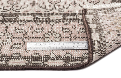 Load image 1 in gallery view. Pink and brown traditional patterned rug with a folded corner and a metal ruler for scale on a white background.