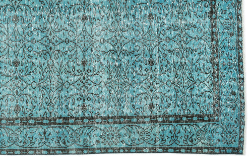 Load image 1 in gallery view. Turquoise and black distressed rug with a traditional floral medallion pattern and a geometric border.