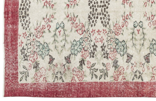 Load image 1 in gallery view. Distressed cream rug with a red border and a faded floral pattern in shades of red, green, and black.