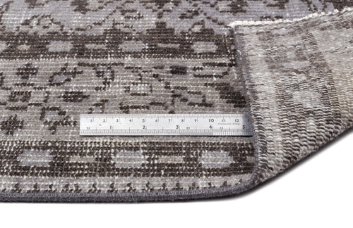 Load image 1 in gallery view. Grey and charcoal distressed traditional rug with a folded corner and a stainless steel ruler for scale.