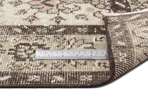 Load image 1 in gallery view. A close-up of the Lagata - Vintage Floral Rug (6'2 x 9'9), with a folded corner revealing the underside. A metal ruler placed on the flatwoven surface displays measurements in centimeters and inches for scale.