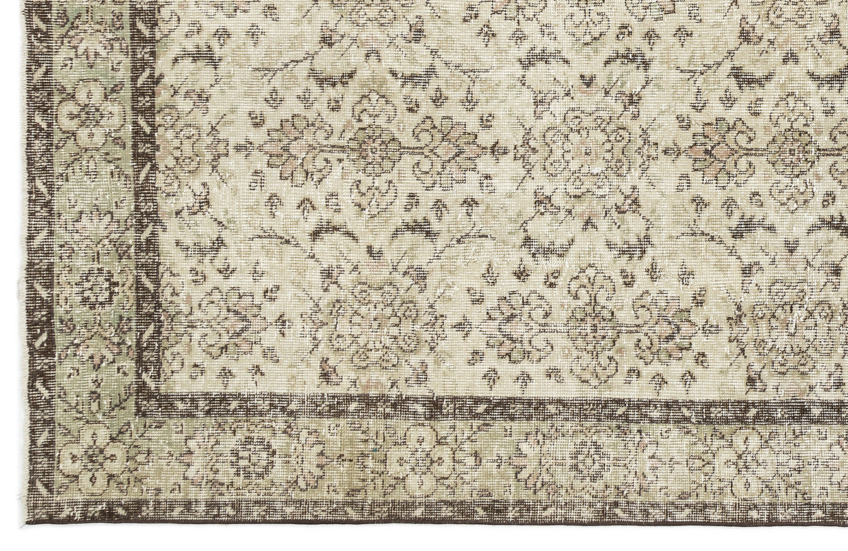 A close-up of the Lagata - Vintage Floral Rug (6'2" x 9'9") showcases its beige background, detailed floral patterns, and a dark brown and green border.