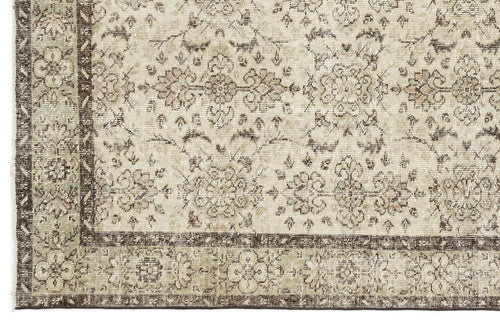 Load image 1 in gallery view. A close-up of the Lagata - Vintage Floral Rug (6'2" x 9'9") showcases its beige background, detailed floral patterns, and a dark brown and green border.