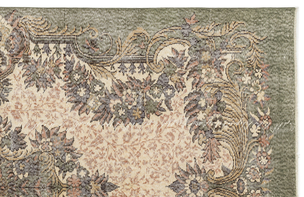 Sage green and cream rug with a traditional floral medallion pattern and distressed texture.