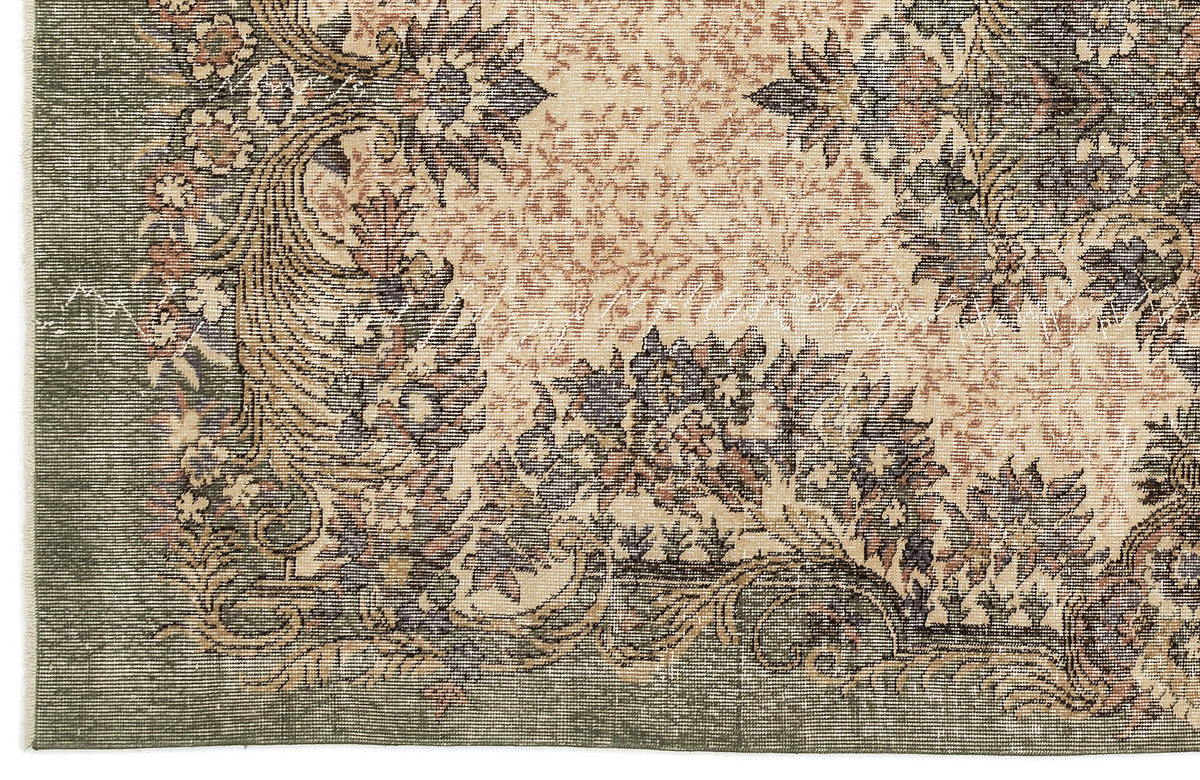 Sage green and beige traditional rug with a distressed floral medallion pattern and ornate border.