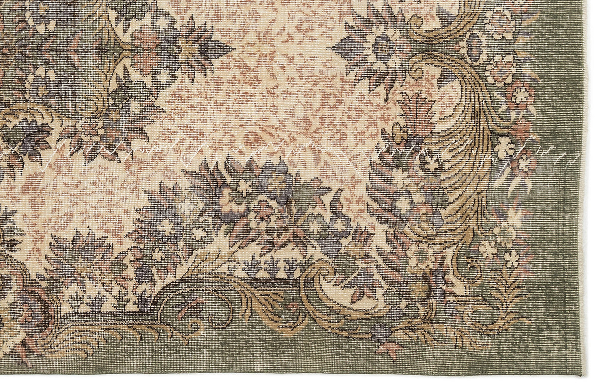 Sage green and beige rug with a traditional floral medallion pattern and distressed, vintage-style finish.