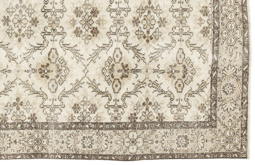 Load image 1 in gallery view. Beige and brown distressed rug with a traditional floral medallion pattern and a wide decorative border.