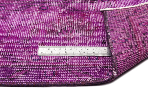 Load image 1 in gallery view. Distressed magenta and purple vintage-style rug with a folded corner and a metal ruler for scale.