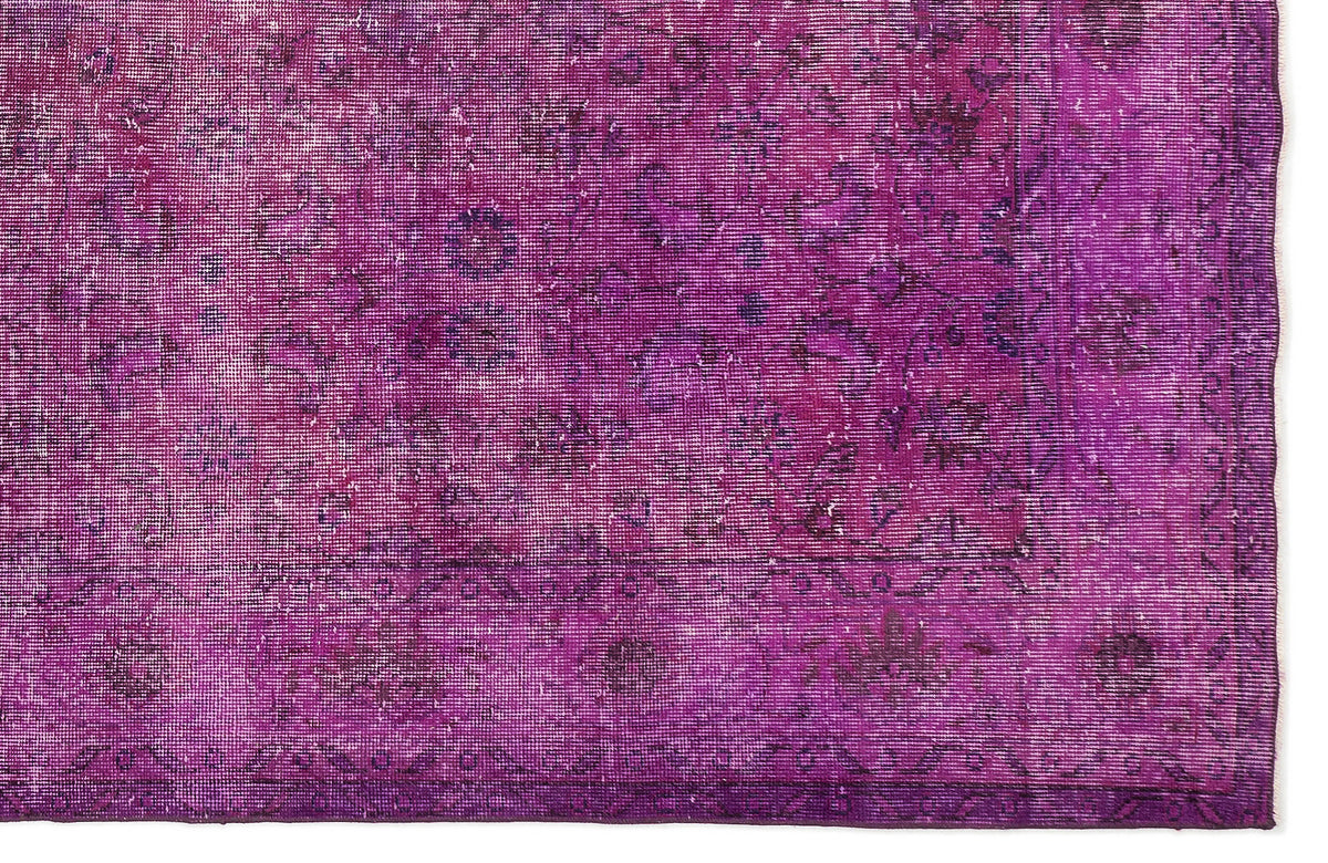 Magenta distressed vintage-style rug with a faded traditional floral medallion pattern.