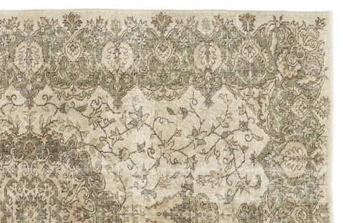 Load image 1 in gallery view. A section of the Seudian Vintage Medallion Rug (5'9 x 8'9) displays faded floral and geometric patterns in green, beige, and cream. The top border highlights repeating leaf and flower motifs, adding to its vintage charm.