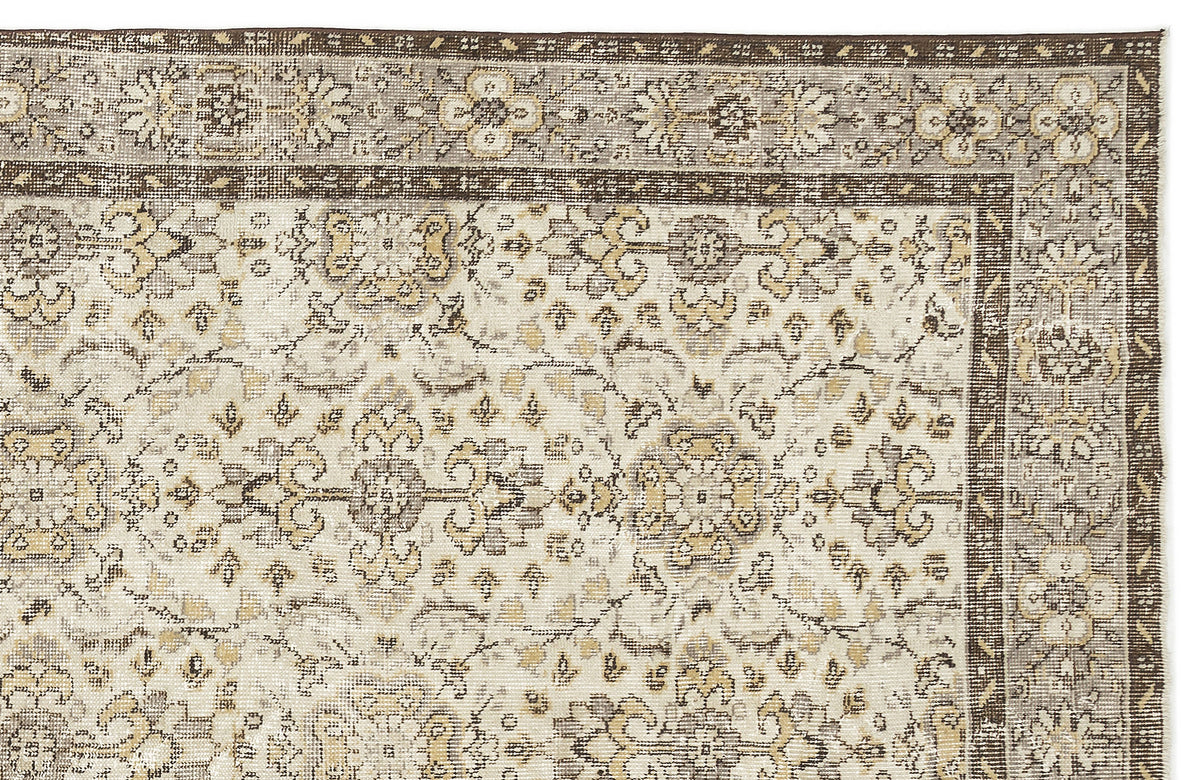 Beige and brown traditional rug with a distressed floral medallion pattern and a detailed geometric border.