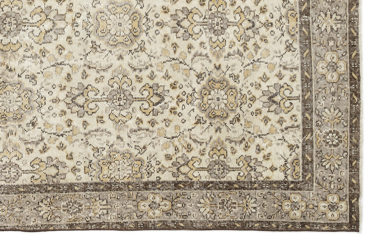 Cream, beige, and dark brown rug with a traditional distressed floral medallion pattern and a wide decorative border.