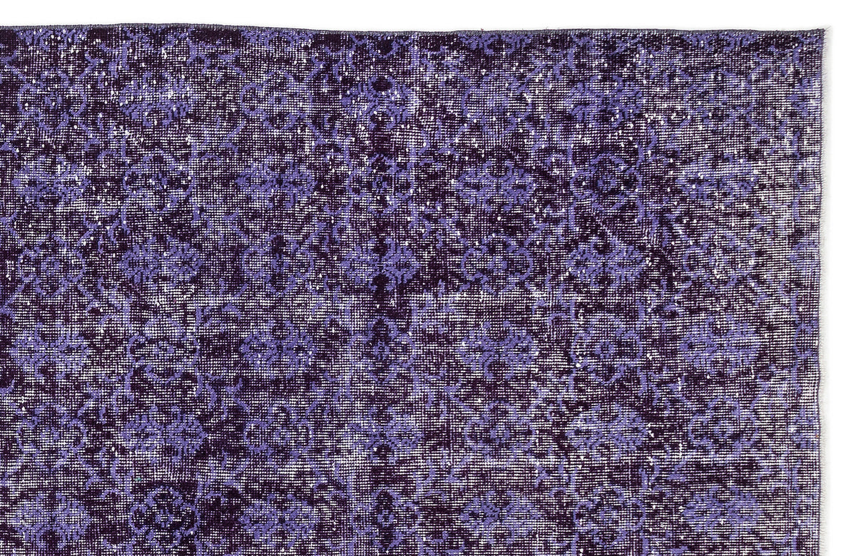 Deep purple and lavender distressed rug with a repeating floral medallion pattern on a white background.