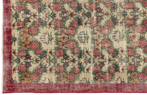 Load image 1 in gallery view. Distressed beige rug with a floral pattern in red, green, and purple, featuring a solid red border.