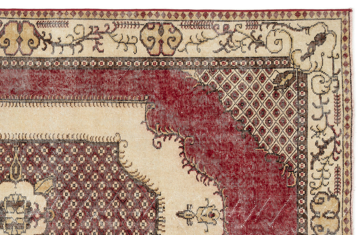 Cream and red traditional rug with a distressed geometric medallion pattern and intricate floral border.