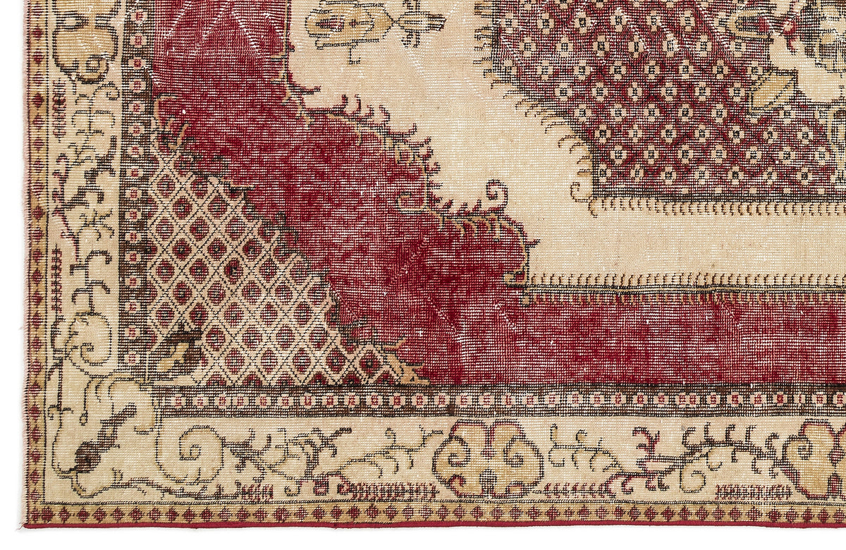 Distressed red and beige rug with a traditional medallion pattern, geometric lattice details, and a floral border.