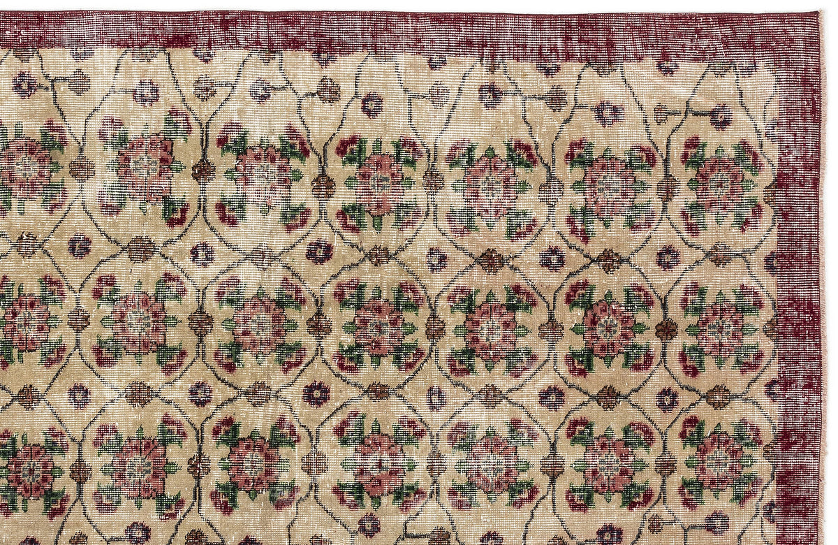 Beige rug with a dark red border and a repeating floral medallion pattern in red, green, and brown on a grid.