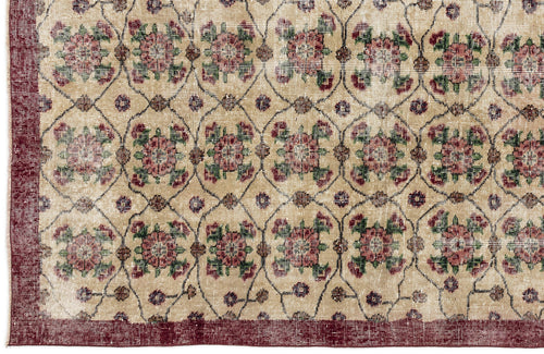 Load image 1 in gallery view. Beige rug with a repeating floral medallion pattern in red and green, enclosed by a dark red border.