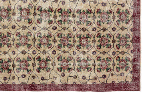 Load image 1 in gallery view. Beige rug with a repeating floral medallion pattern in red and green, enclosed by a dark red border.